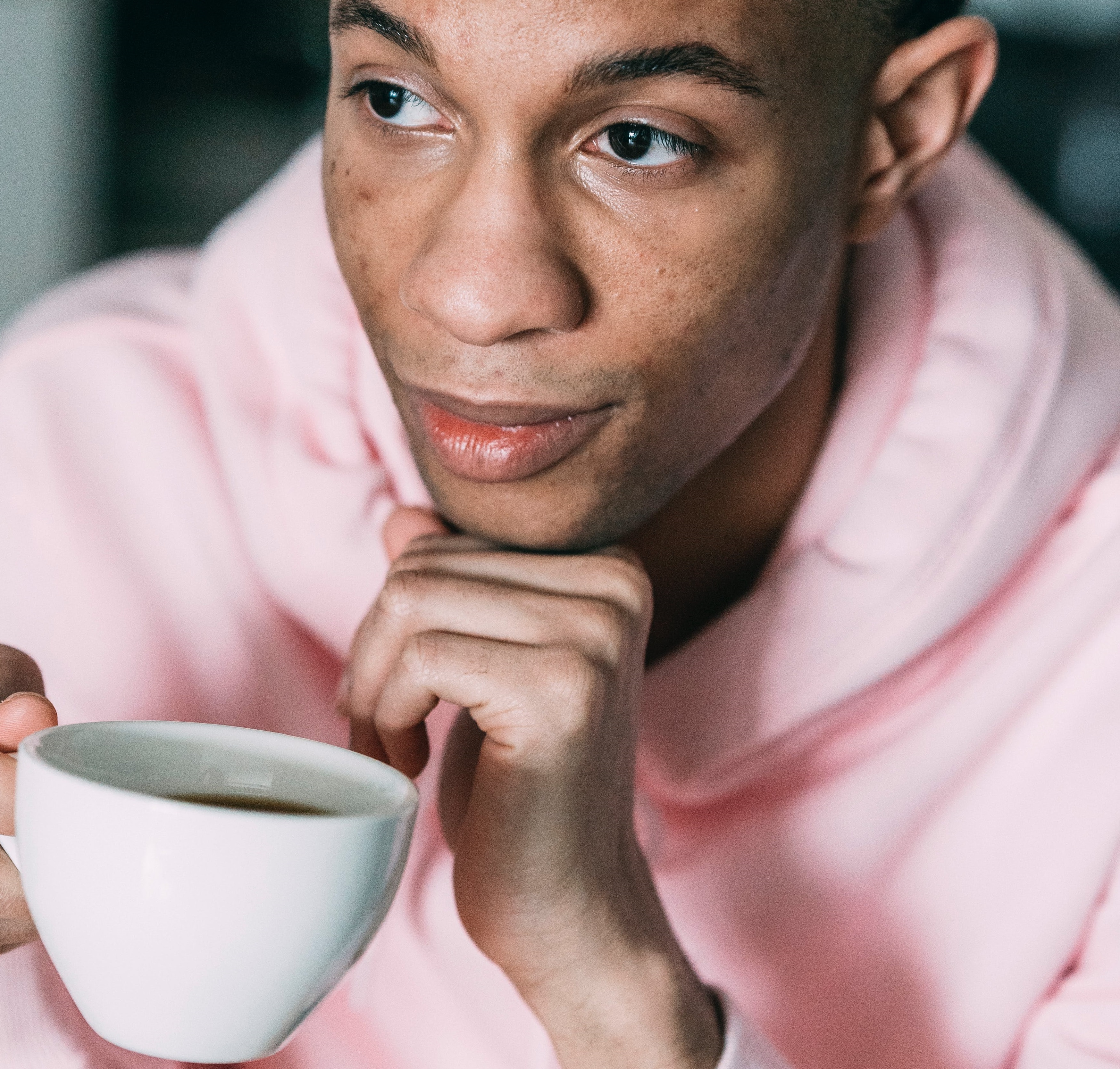 person in pink hoodie drinking coffee