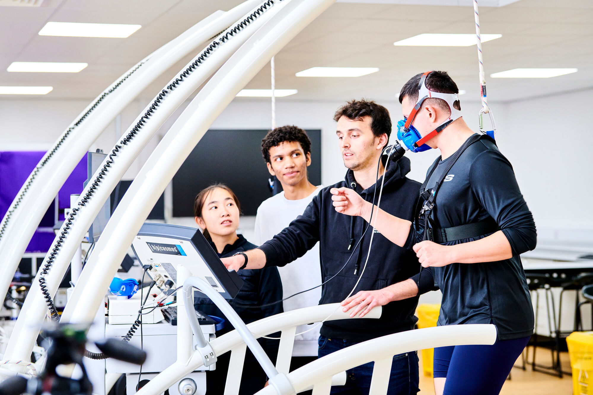 A technician working with students in a sports laboratory