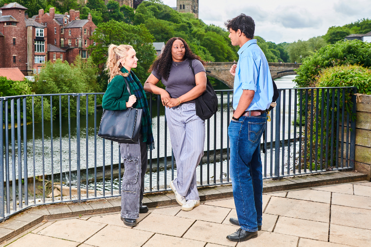 Three students in conversation with Cathedral in background