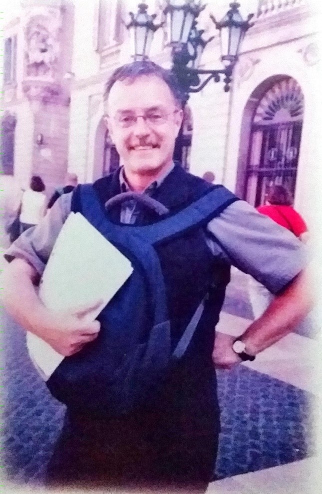 Dr John Wreglesworth stands by a building, holding paperwork.