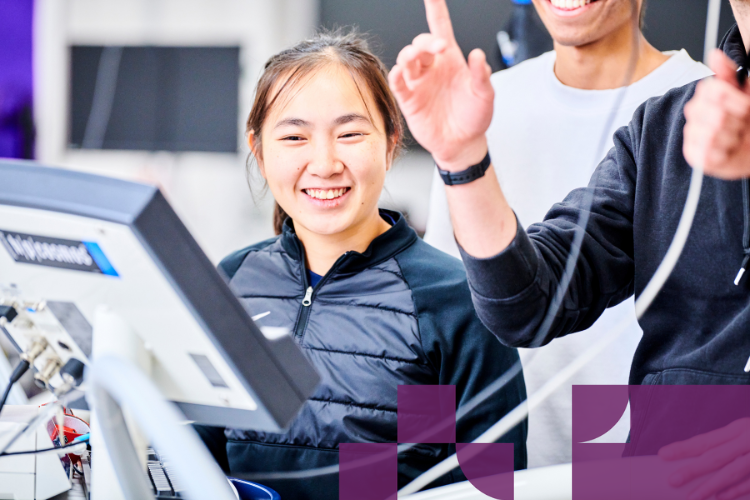 Student laughing, looking at a screen