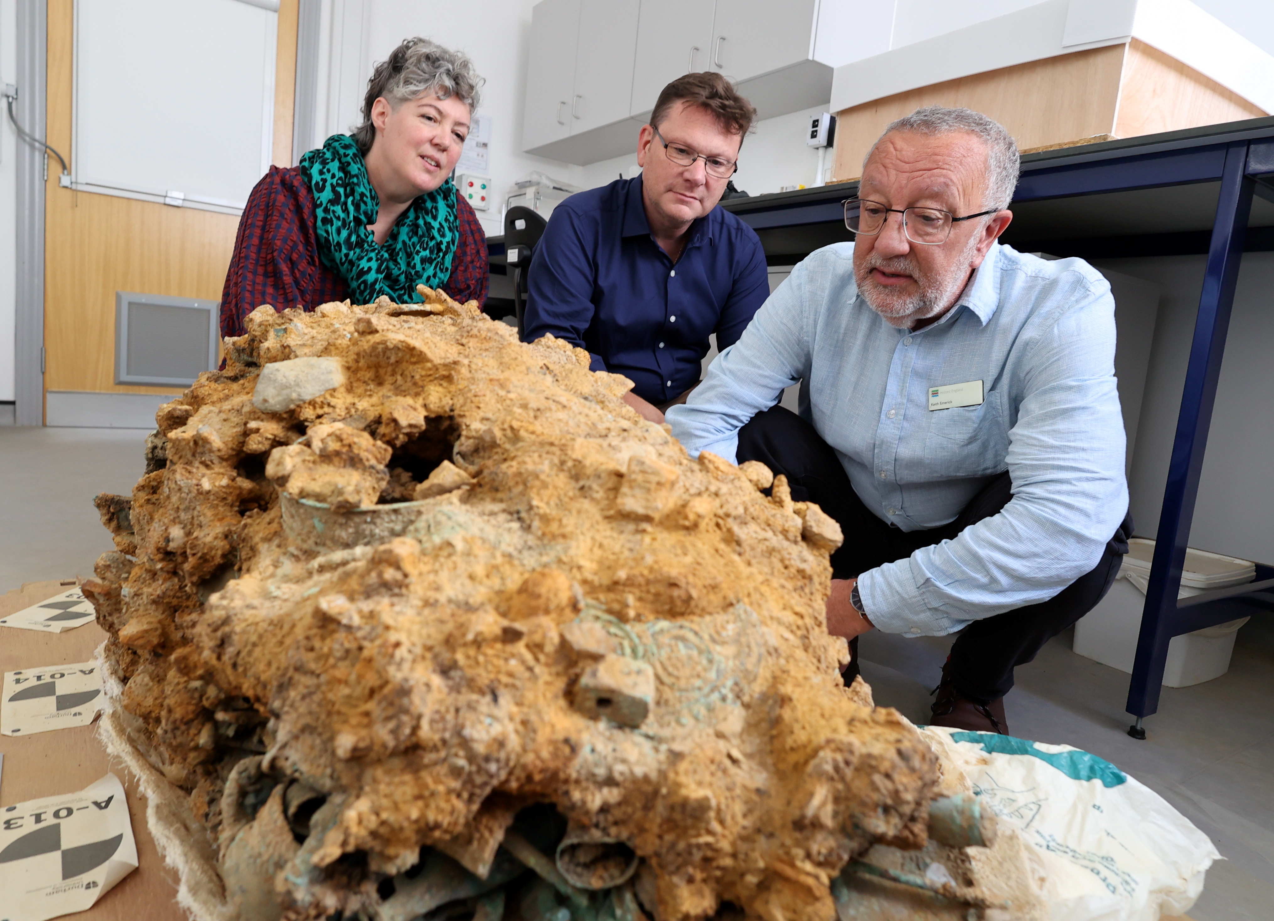 Dr Sophia Adams, Professor Tom Moore and Keith Emerick examining the Block, a huge chunk of Iron Age metalwork that has corroded together.