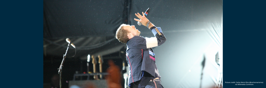 Lead singer of Coldplay, Chris Martin, performing at a concert.
