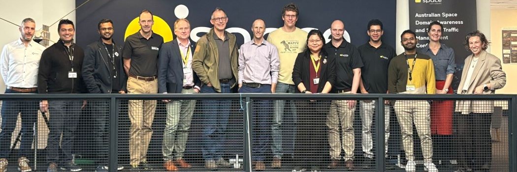 A group of people standing on a balcony, facing the camera