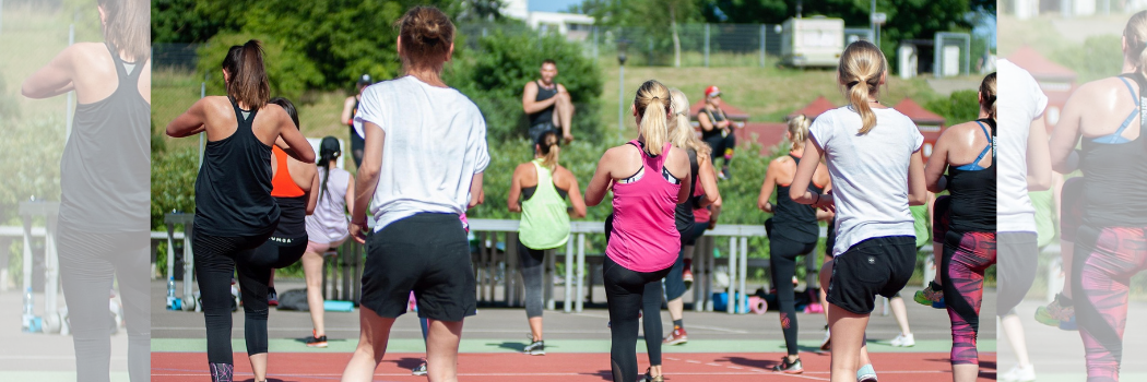 A group of people in gym clothes exercising outdoors
