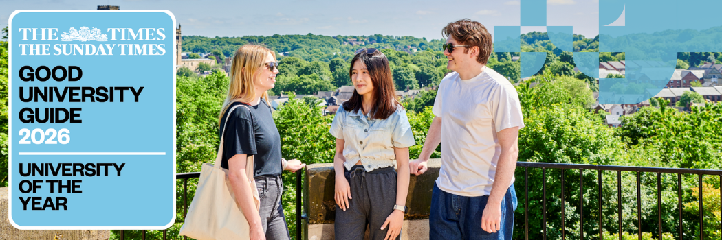 Three students outside in the sun chatting and smiling with the cathedral in the background