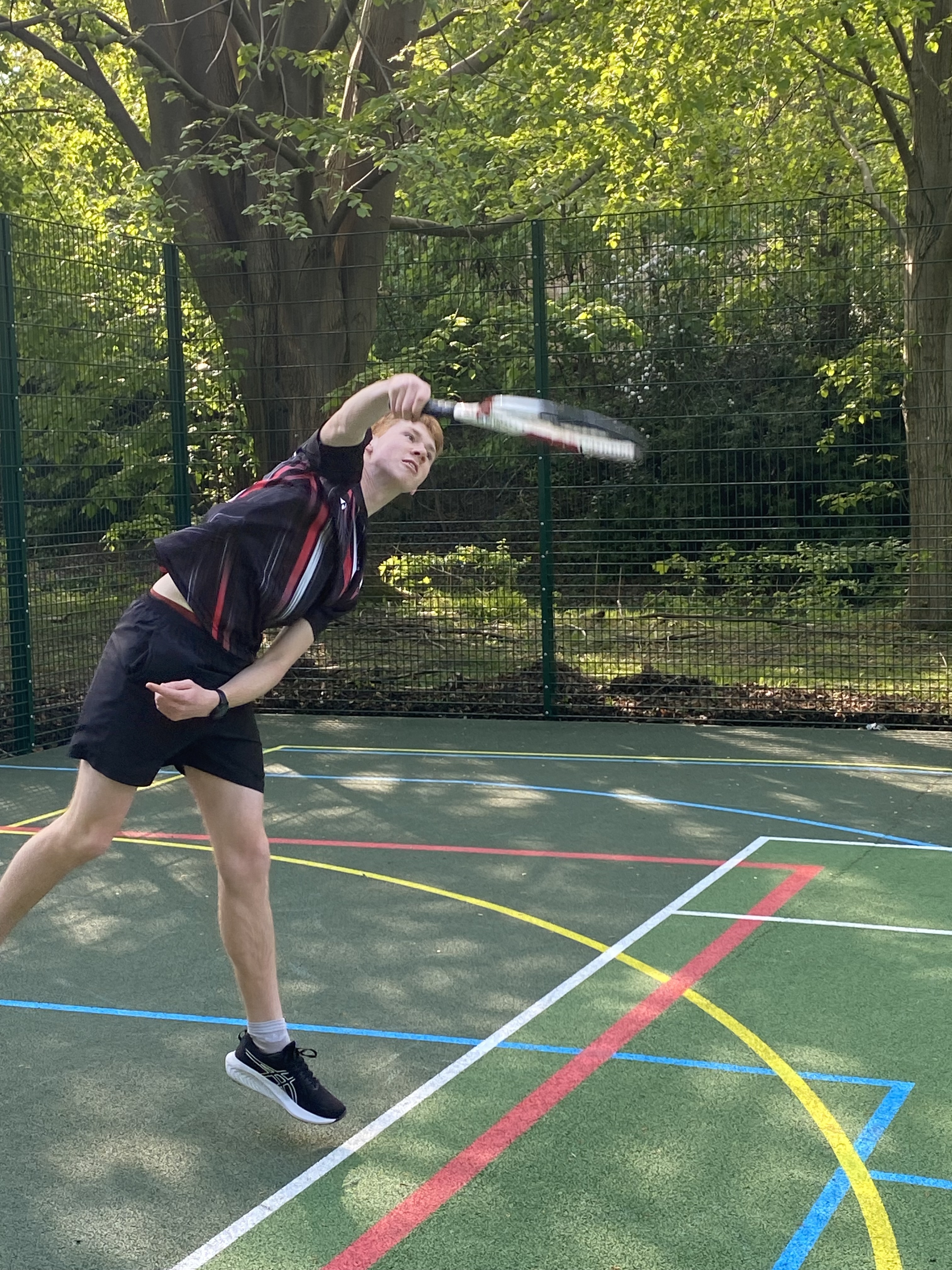 A male student playing tennis