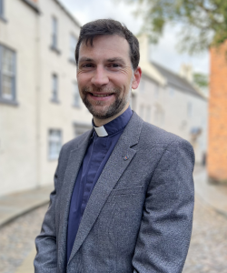 Head and shoulders of the warden of St Johns College
