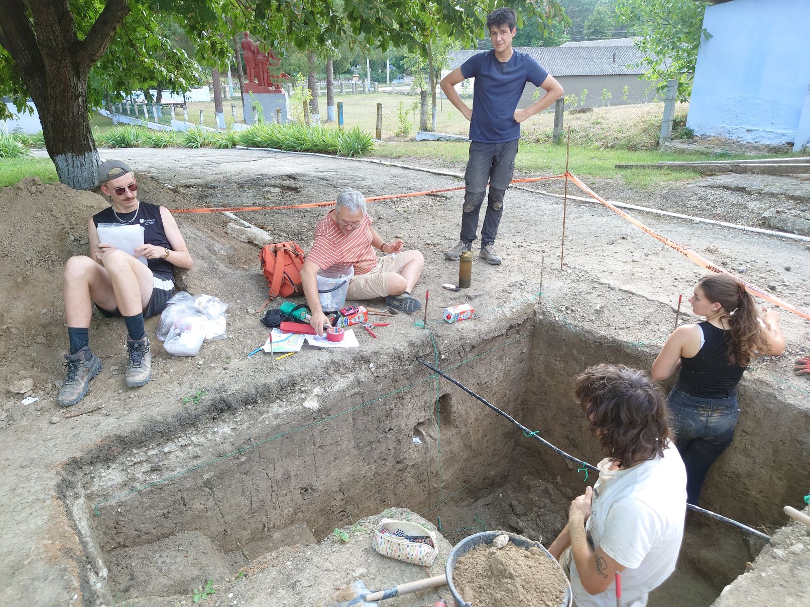 Part of the project team at one of the archaeological trenches, conducting sedimentology sampling. Two are inside the trench, three are standing on the side.