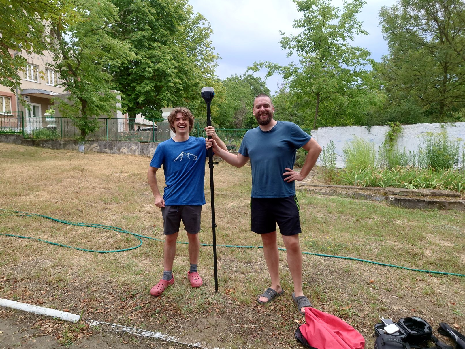 Two Durham Archaeology students stand holding equipment and smiling
