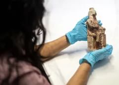 Black textured foam mat with an array of archaeological finds on top of it.