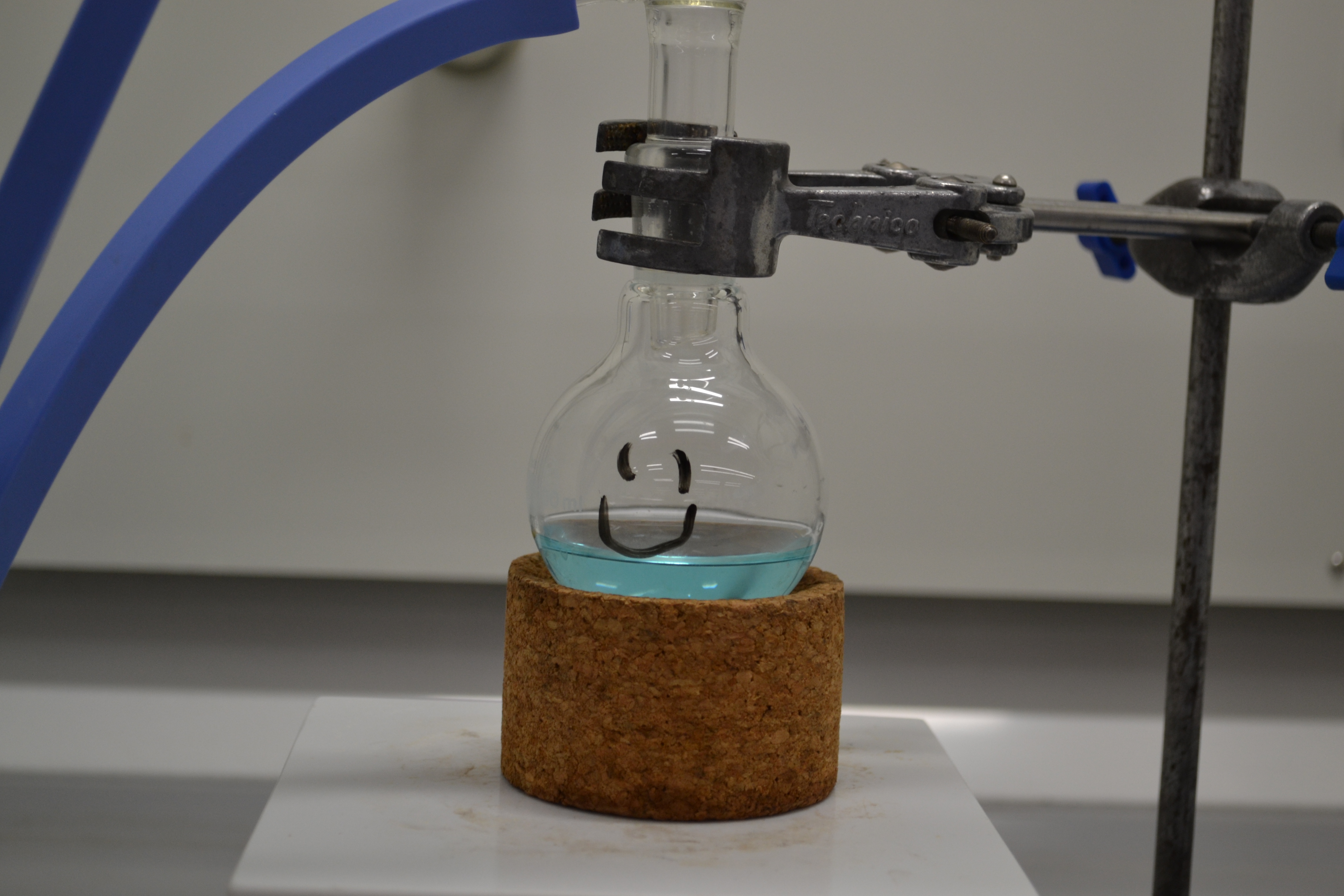 A vial with a blue liquid and a smiley face.