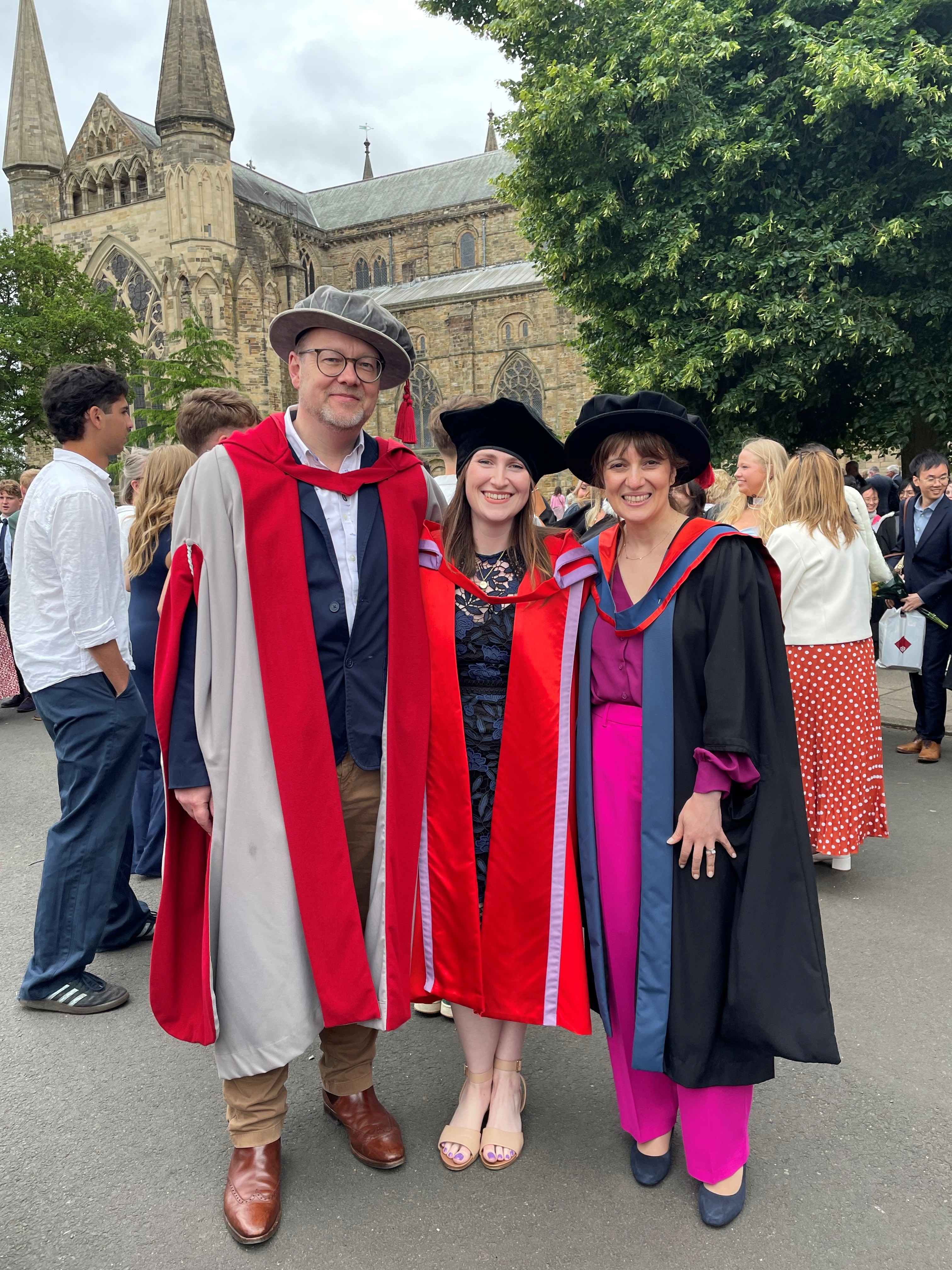 DR Emma Maslin poses with DR Jonathan Tummons and Dr Cristina Costa after the graduation ceremony in July 2025