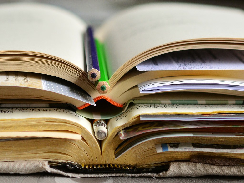 Open books with pencils marking the pages