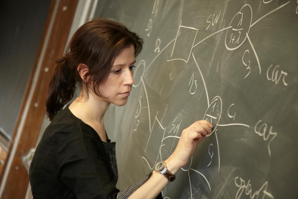 A woman writing on a blackboard