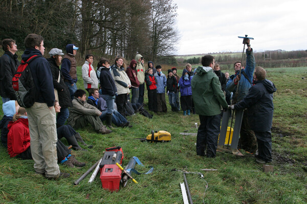 Group of students outdoors watching equipment being assembled