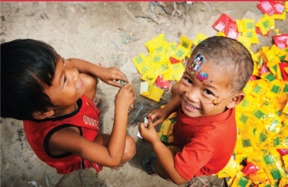 Two children playing whilst looking up at the camera