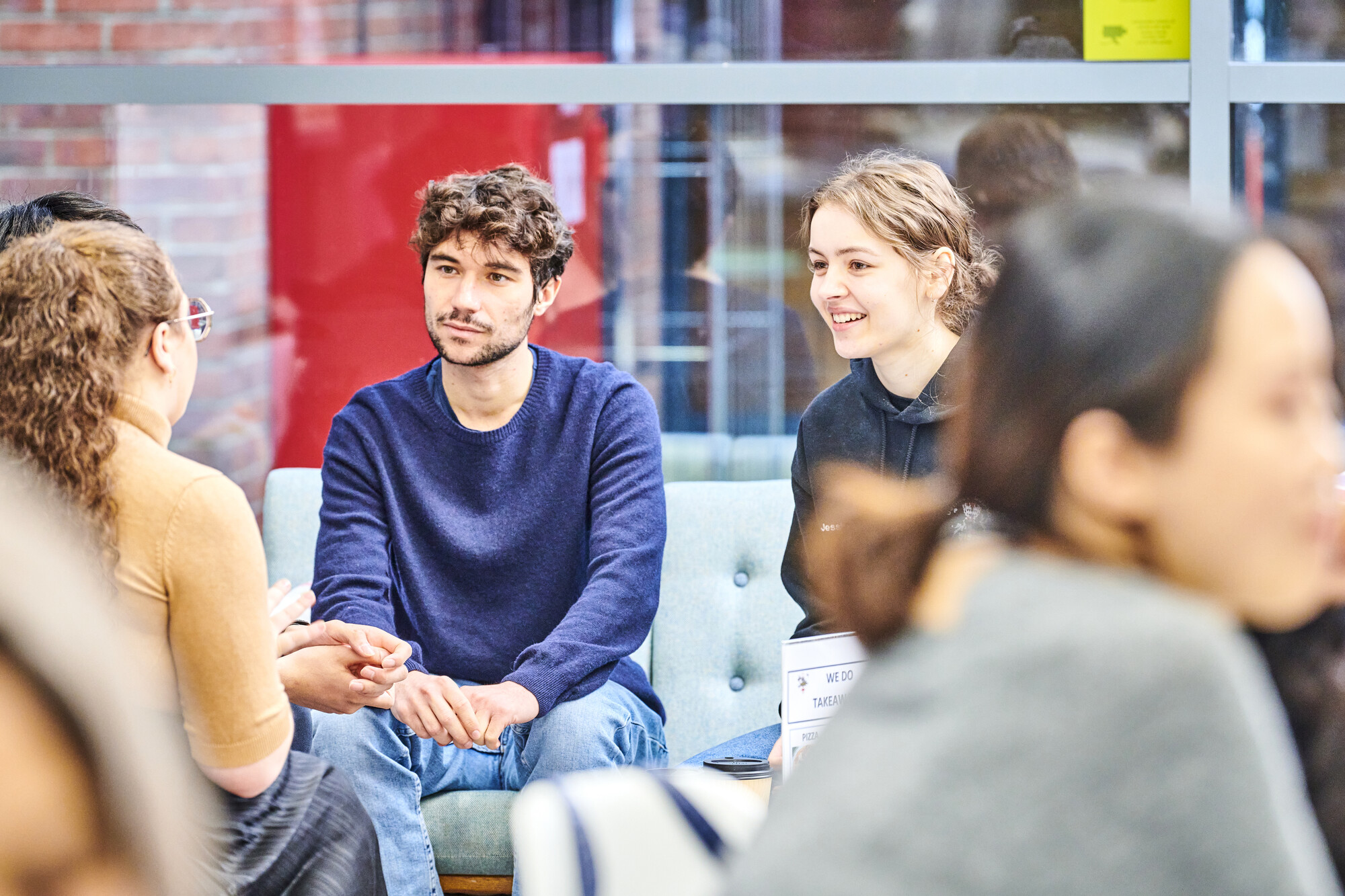 A group of students is sitting together talking