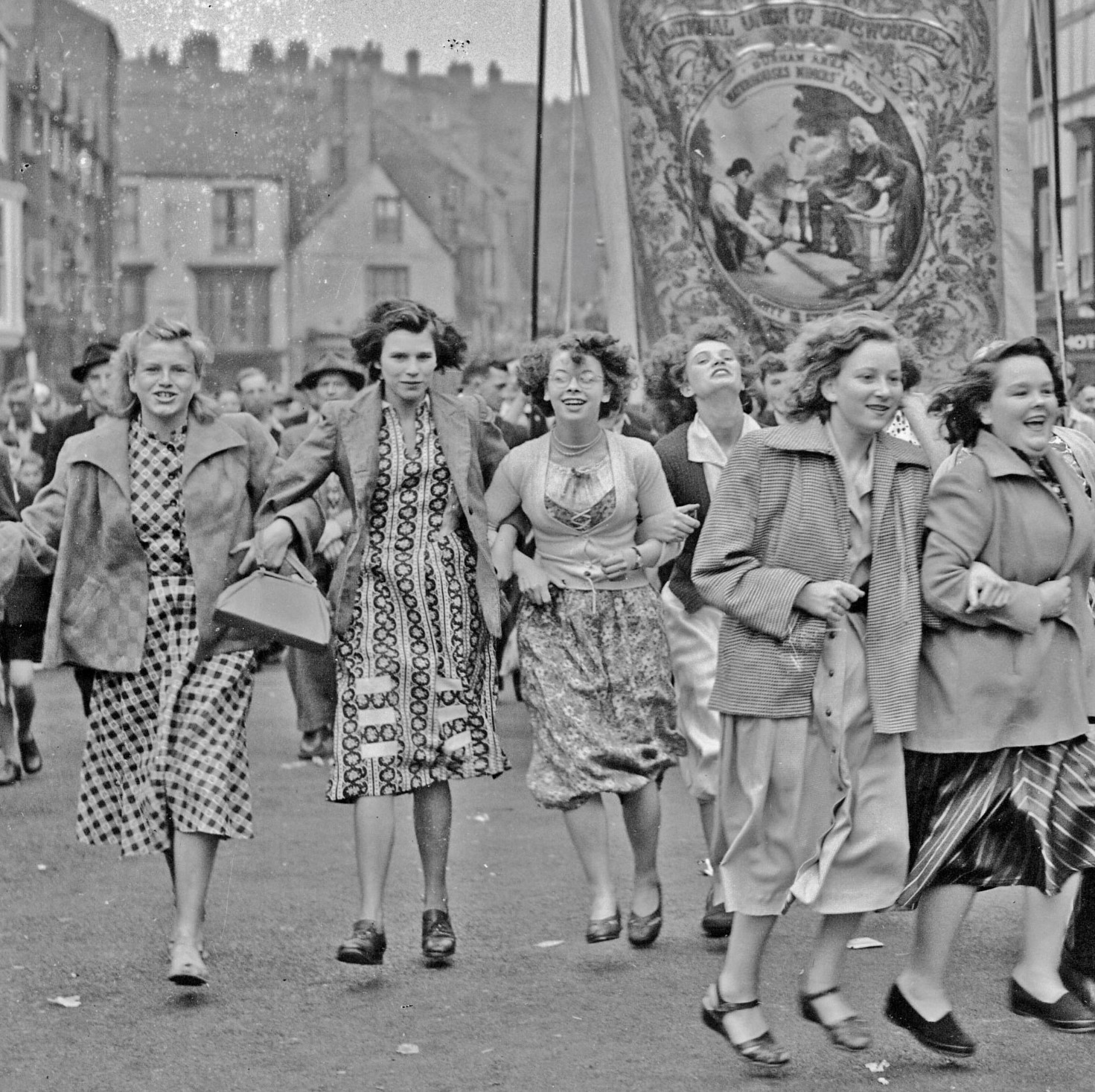 Black and white photo of good-spirited young girls taking part in labour march