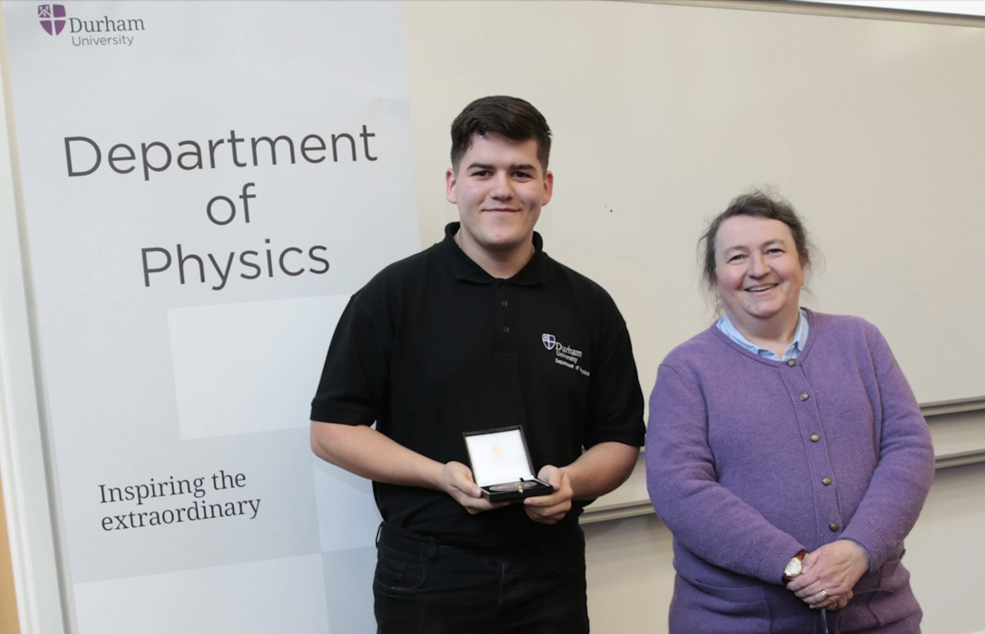 Spencer Davies receiving a staff excellence award from Prof Paula Chadwick