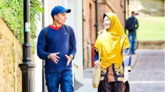 Two students walking down Bow Lane in Durham, smiling and talking to one another.