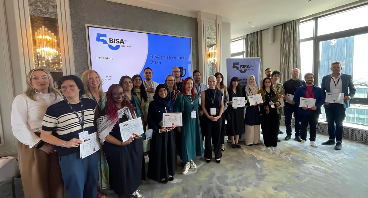 A group of around 20 people holding up certificates