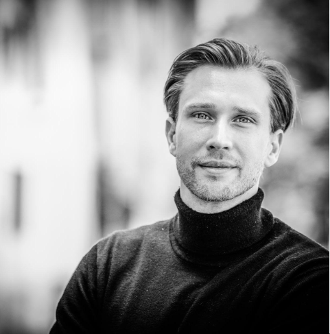 a black and white image of a man wearing a black rollneck top