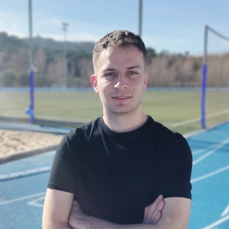 Victor posing outside on a tennis court