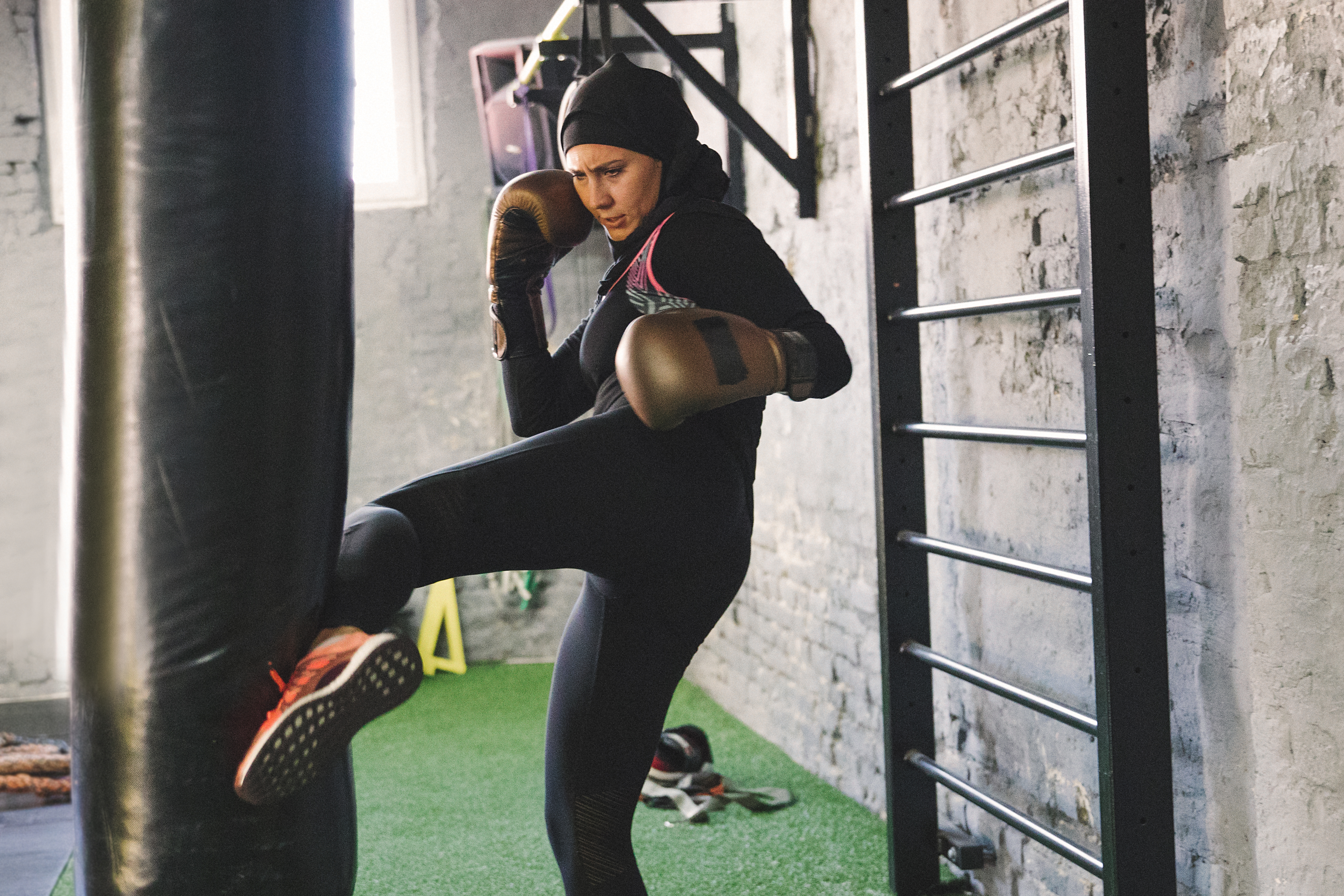 Someone side kicking a punchbag