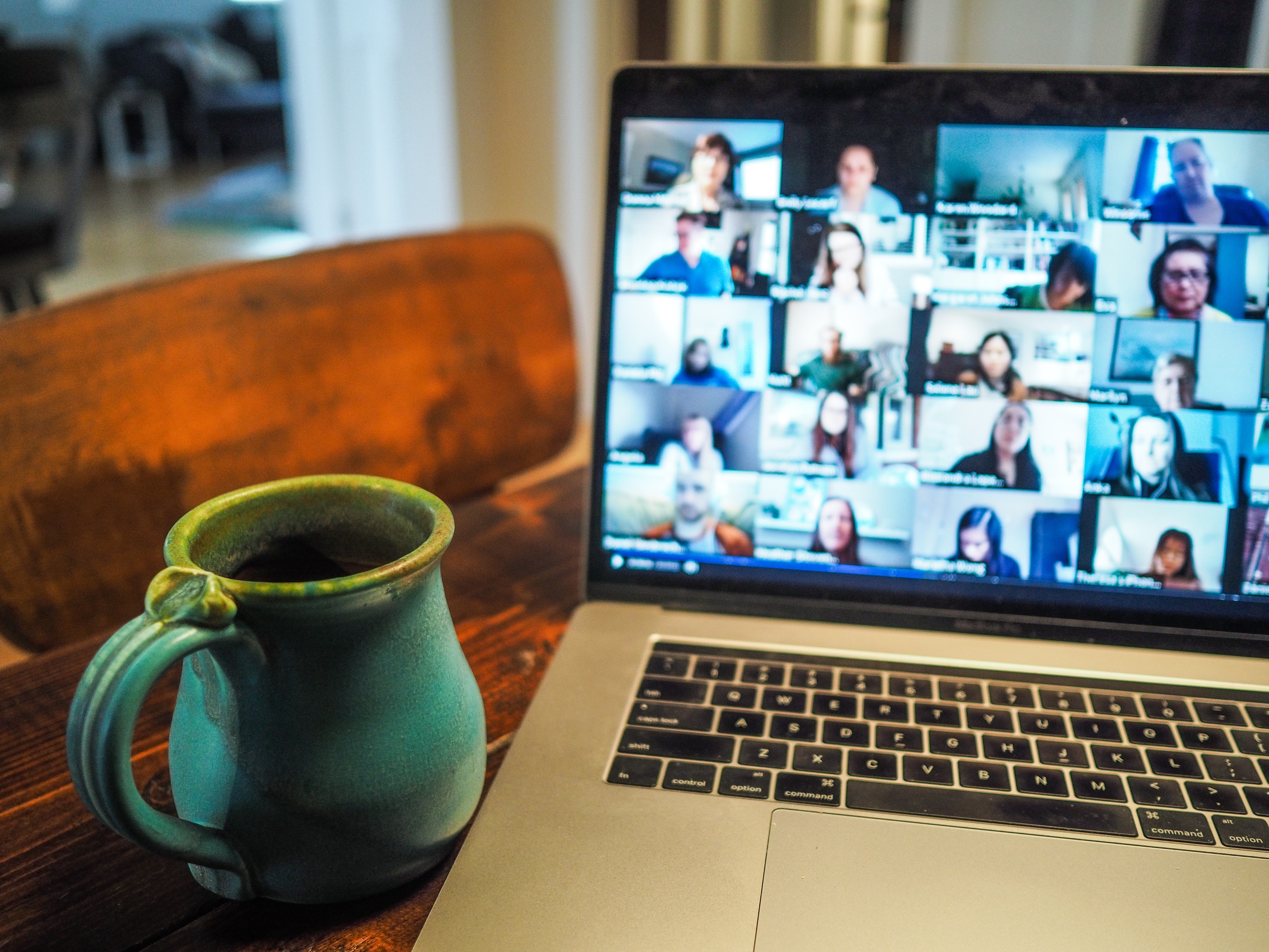 Image of a cup of coffee next to a computer screen on a conference call