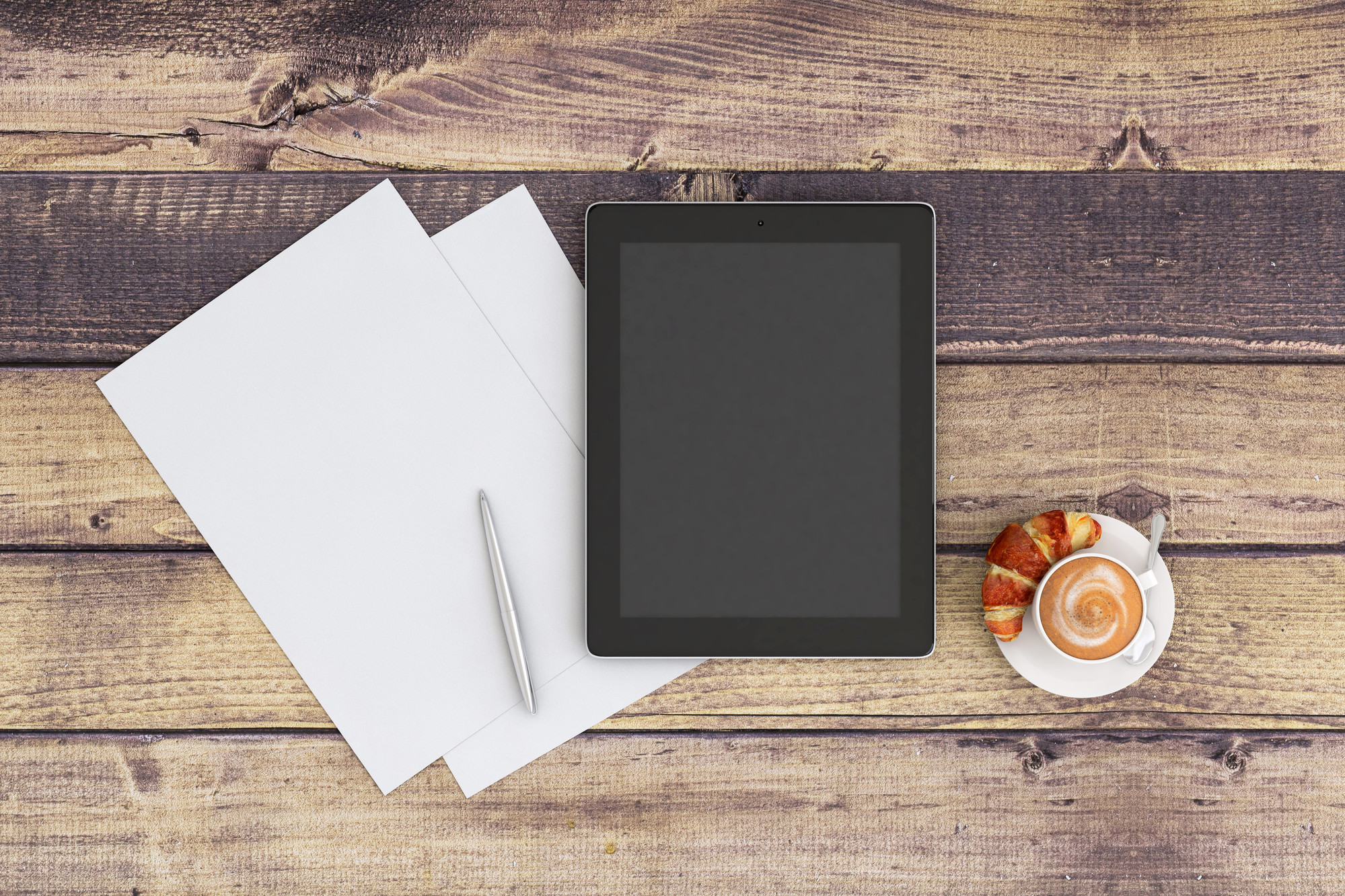 Tablet on table with paper and food