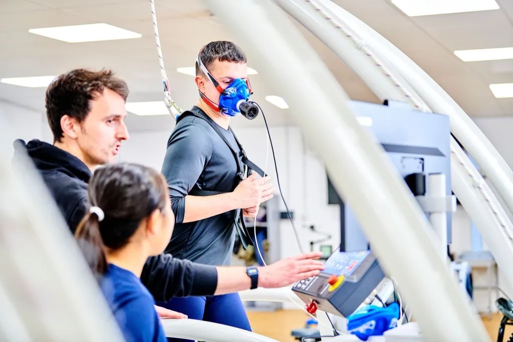 Students using oxygen measuring equipment on a treadmill
