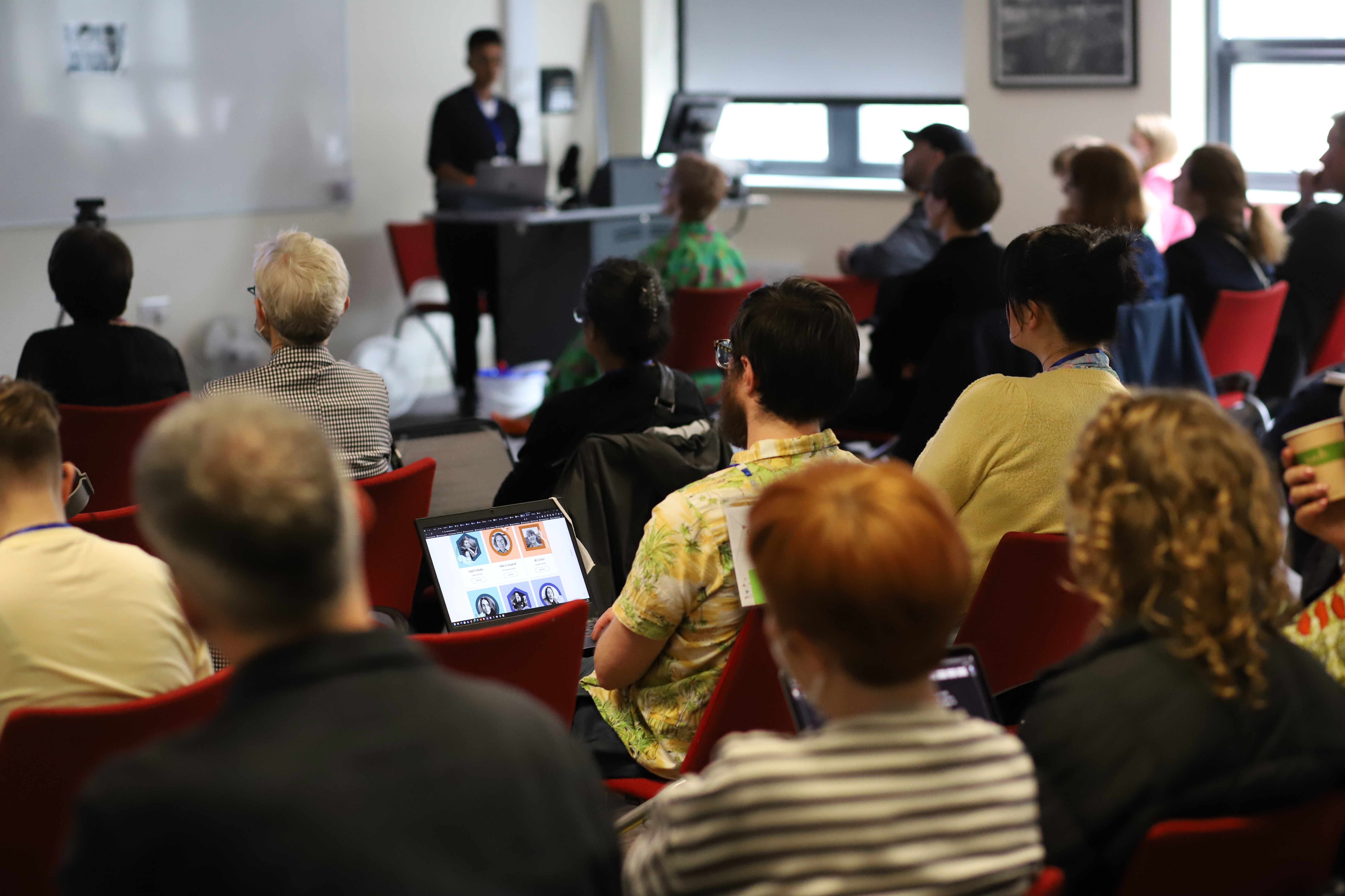 Photograph of conference participants listening to a speaker.