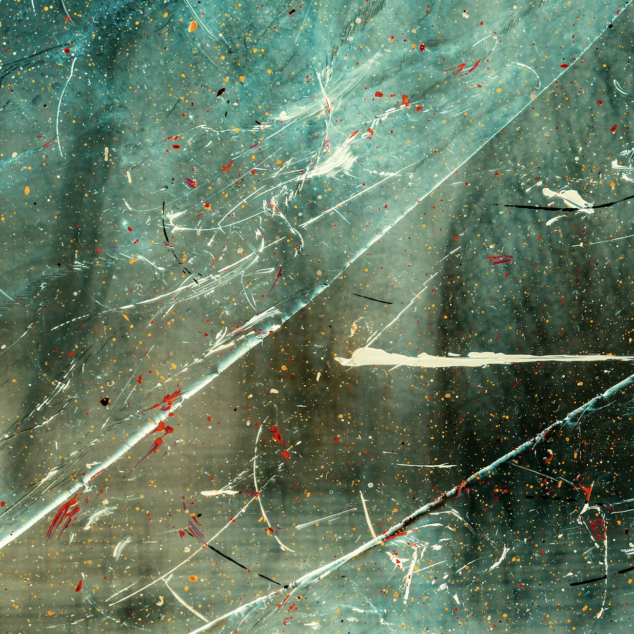 Water and paint droplets on a cracked glass pane