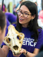 Female person holding a mammal skull